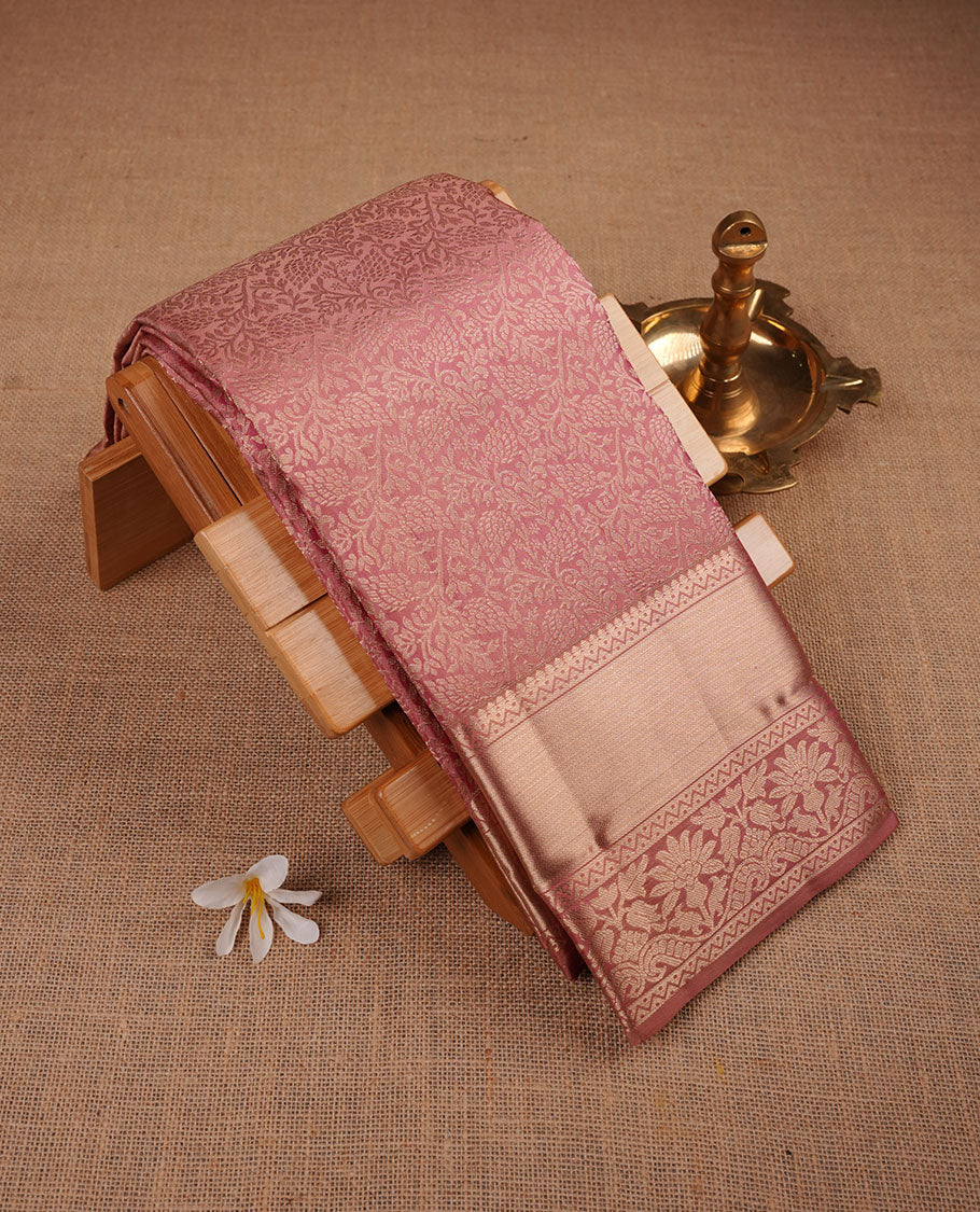 Powder pink Kancheepuram silk saree featuring floral jacquard on the body with a traditional border, paired with a matching blouse piece.