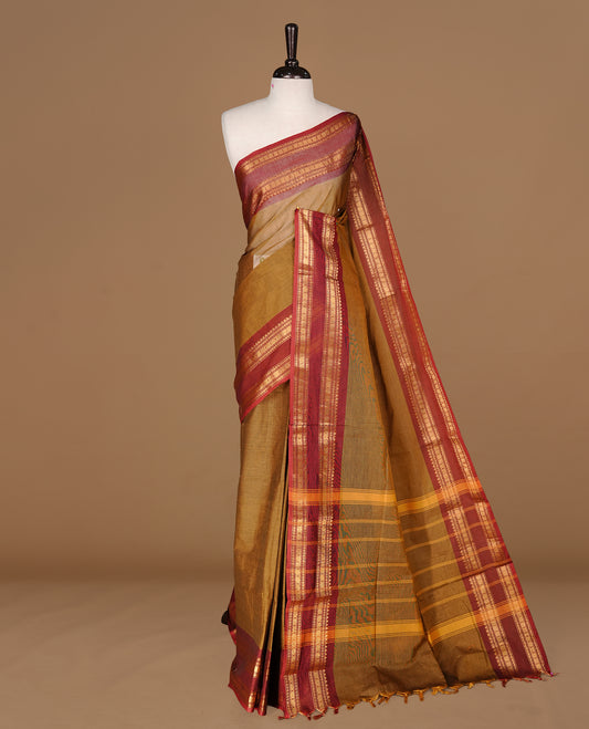 Dark olive colour Chettinad cotton saree featuring Elegant plain body, complemented by contrast Maroon colour with gold zari border, paired with matching blouse piece.