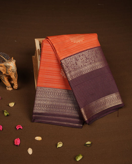 Dark Rust orange colour semi silk saree featuring gold zari stripes and floral motifs on body highlighting contrast dark chocolate gold zari peacock border , paired with matching blouse