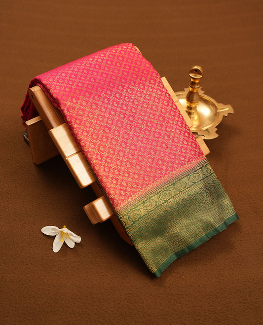 Magenta colour semi silk brocade saree featuring intricate Gold Diamond patterns across the body, complemented by a contrast Green colour woven border and pallu, paired with a matching blouse.