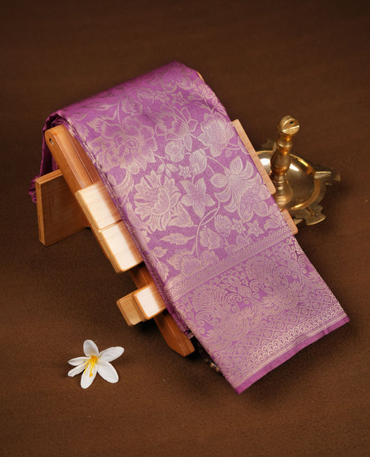Lavender Purple colour semi soft silk brocade saree featuring elegant floral woven motifs across the body, finished with a self colour ornate border and pallu, paired with a matching blouse.