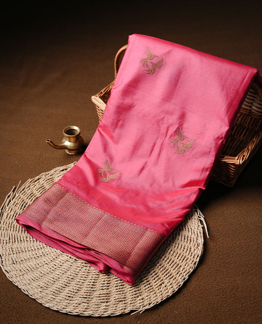 Pinkish red colour semi banaras tussar silk saree highlighting gold zari bird motifs on body, complemented by self colour with antique zari border, paired with matching blouse piece.