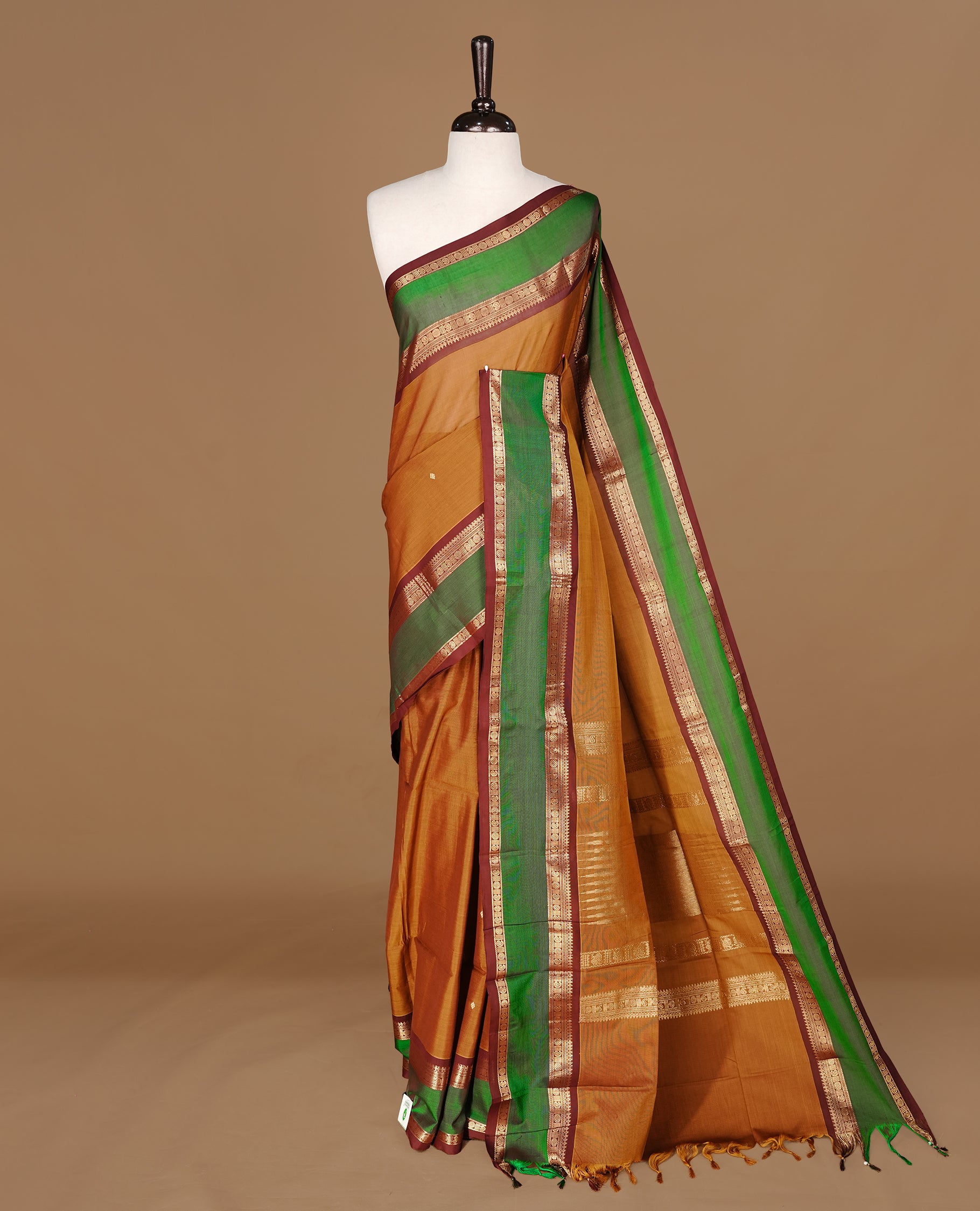Mustard Olive Colour Chettinad cotton saree featuring Gold zari motifs on body , complemented by contrast Chocolate & Green colour with traditional border, comes with matching blouse piece.