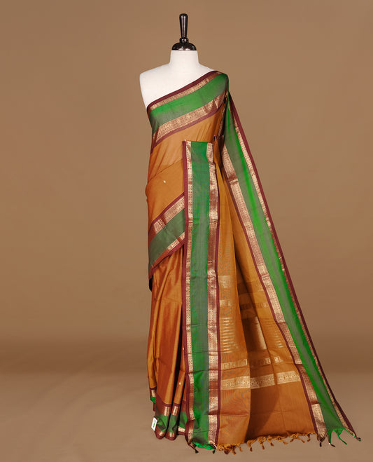 Mustard Olive Colour Chettinad cotton saree featuring Gold zari motifs on body , complemented by contrast Chocolate & Green colour with traditional border, comes with matching blouse piece.