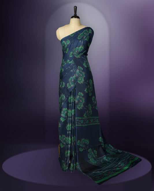 Navy Blue colour saree enhanced with a vibrant green colour floral prints on body & pallu, and  comes with a matching blouse.