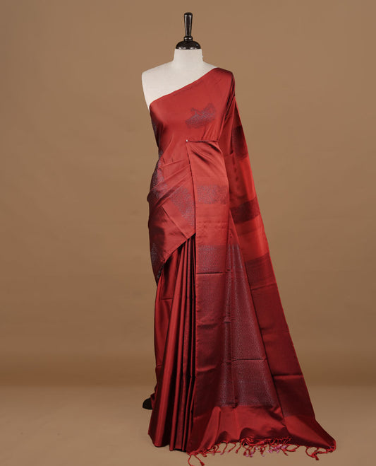 Red soft silk saree features a sleek borderless design with intricate antique zari motifs, flowing into a seamless self colored pallu and a matching blouse piece.