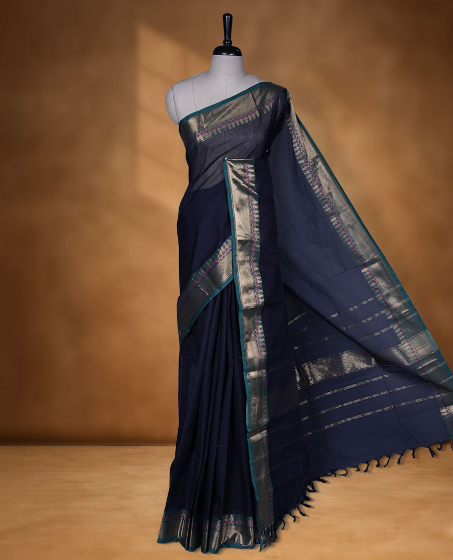 Dark Blue colour chettinad cotton saree featuring Elegant plain body, contrast green colour border with gold zari border, pallu and paired with matching blouse.