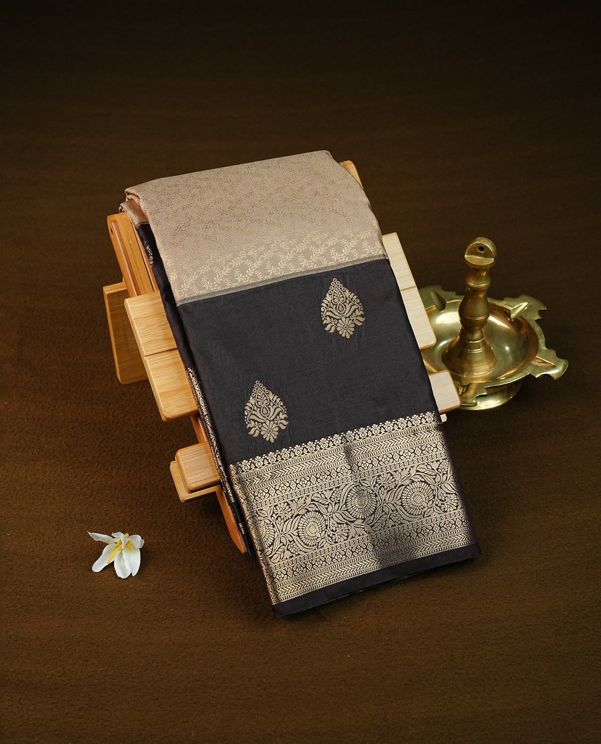 Light mocha colour semi wedding saree featuring gold zari motifs across the body, complemented by contrast Chocolate brown colour traditional border. Comes with a matching blouse piece.