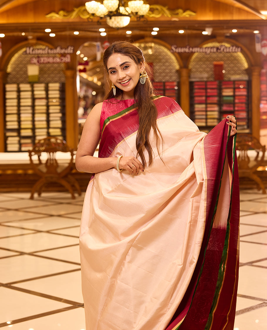 Ivory colour pure kancheepuram silk saree featuring a rich gold zari temple pallu, complemented with a contrast deep red border finished with gold and green selvedge and a matching deep red pallu, beautifully paired with a matching blouse.