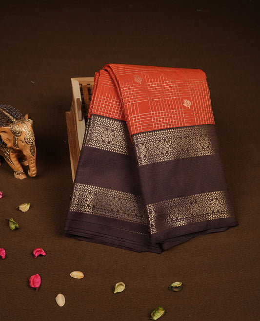 Dark Rust orange colour semi silk saree featuring gold zari checks and small motifs on body highlighting contrast dark chocolate border , paired with matching blouse