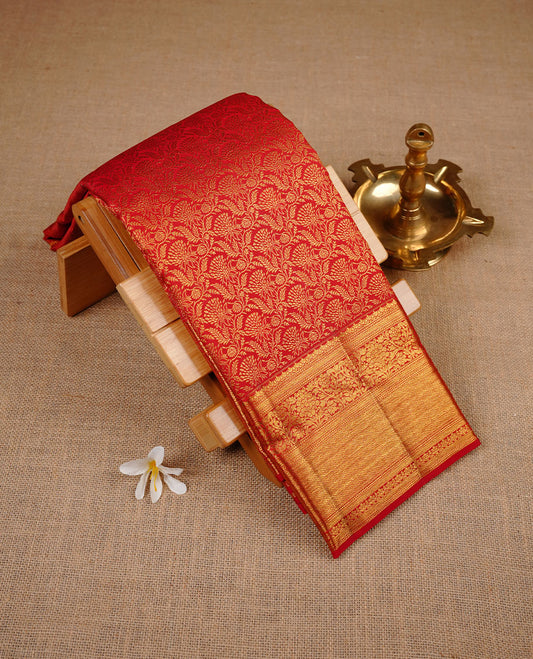 Brick Red colour kancheepuram silk saree featuring gold zari pattern across body, complemented by selfcolour border traditional zari border, paired with matching blouse piece.