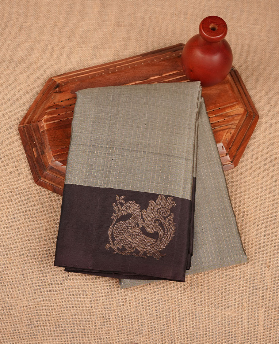 Grey colour soft silk saree featuring vertical lines on body, complemented by contrast burgundy brown with peacock buttas border.