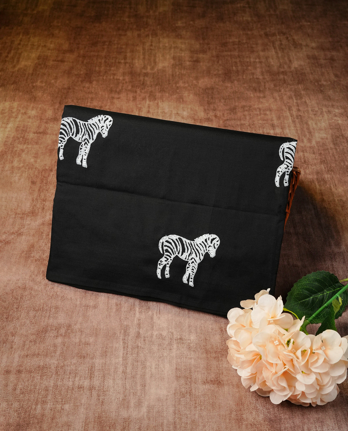 Black colour Polycotton Saree adorned with animal prints across the body and pallu, creating a graceful and minimalist look. Finished with a subtle black border and paired with a matching printed blouse piece,