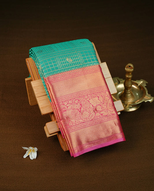 Green colour semi wedding saree featuring gold zari check with peacocok motifs on body complemented by contrast magenta colour with traditional border, comes with macthing blouse piece.