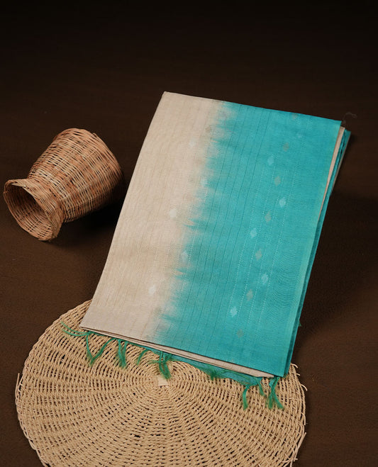 Cream & aqua dye pattern colour semi jute saree highlighting white stripped body, without border and paired with matching blouse.