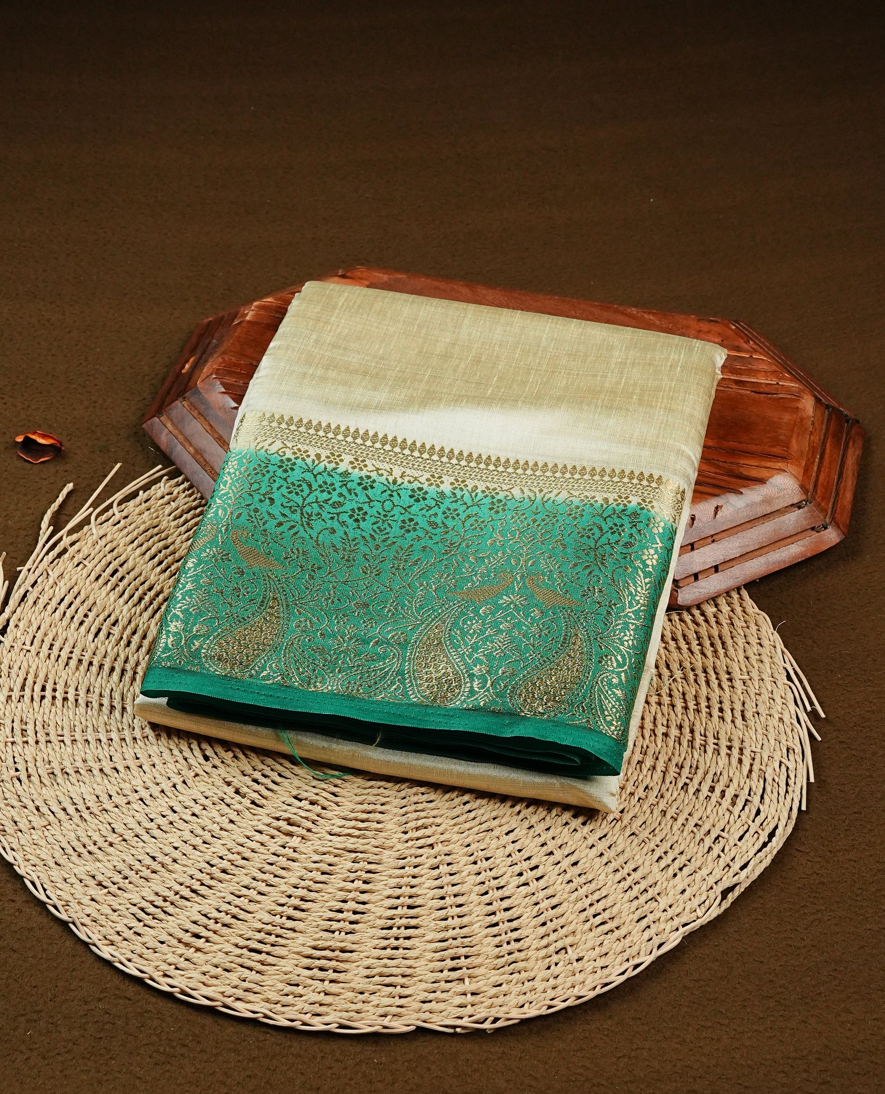 Light gold tussar saree featuring Elegant plain body, complemented by contrast green colour with Gold zari Floral kodi with Peacock Pattern border, comes with matching blouse piece.