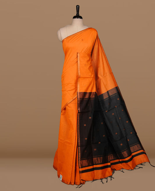 Orange colour Maheshwari cotton saree features elegant gold zari motifs across the body, a classic gold zari border, a striking contrast pallu, and a matching blouse piece.