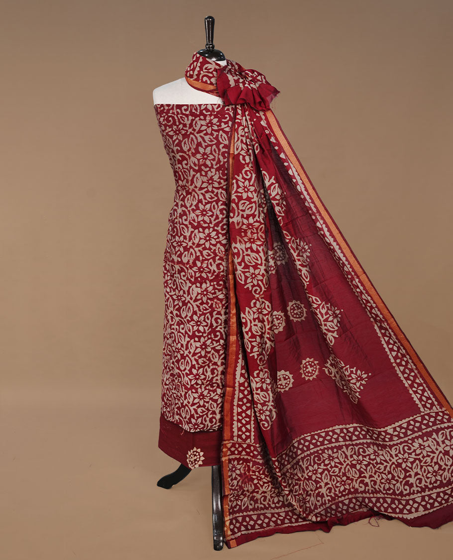 Maroon colour churidhar material featuring cream colour floral kodi print on body, paired with matching bottom and Dupatta.