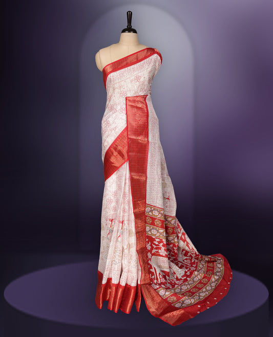 White saree adorned with red motifs, highlighted by a rich red zari border and pallu with traditional patterns and animal designs, paired with a matching blouse.