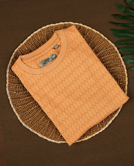 Pastel orange colour T shirt featuring a honeycomb textured pattern, designed with a classic round neck and short sleeves, made from soft breathable fabric for a relaxed and stylish everyday look.