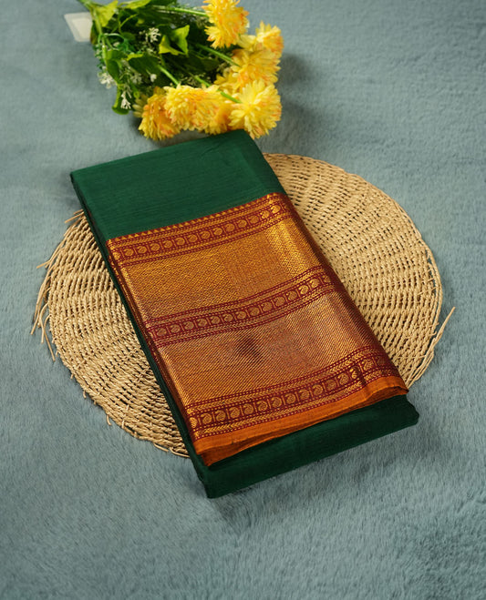 Dark green colour Narayanapattu cotton saree featuring a self coloured body, contrast deep red colour with gold zari border and pallu, pairing a matching blouse piece.