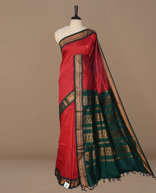 Red colour kalyani cotton saree featuring antique zari motifs on body, complemented by green colour with Antique zari border, paired with matching blouse piece.