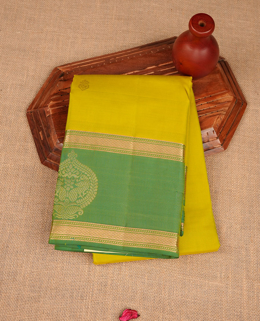 Fluorescent green colour Vasundhara silk saree featuring elegant gold zari buttas across the body, complemented by a contrast leaf green zari border, and paired with a matching blouse piece.