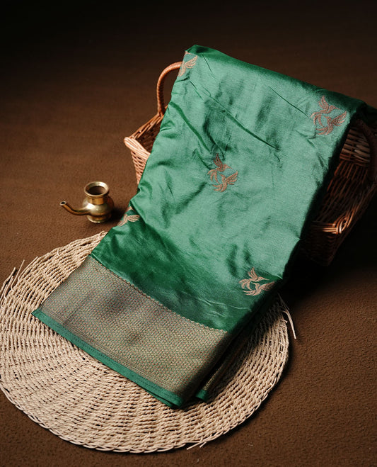 Green colour semi banaras tussar silk saree highlighting gold zari bird motifs on body, complemented by self colour with antique zari border, paired with matching blouse piece.