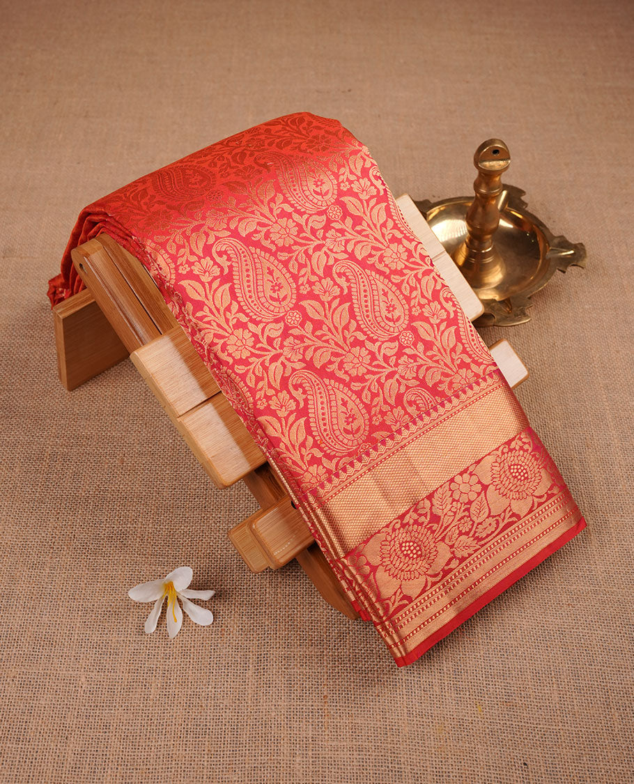 Peach orange colour kancheepuram silk saree featuring floral zari jacquard on body with traditional border, paired with matching blouse piece.