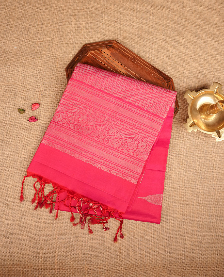 Rani pink colour soft silk saree featuring gold zari motifs on body, complemented by self colour with traditional border with tassel at pallu, paired with matching blouse piece.