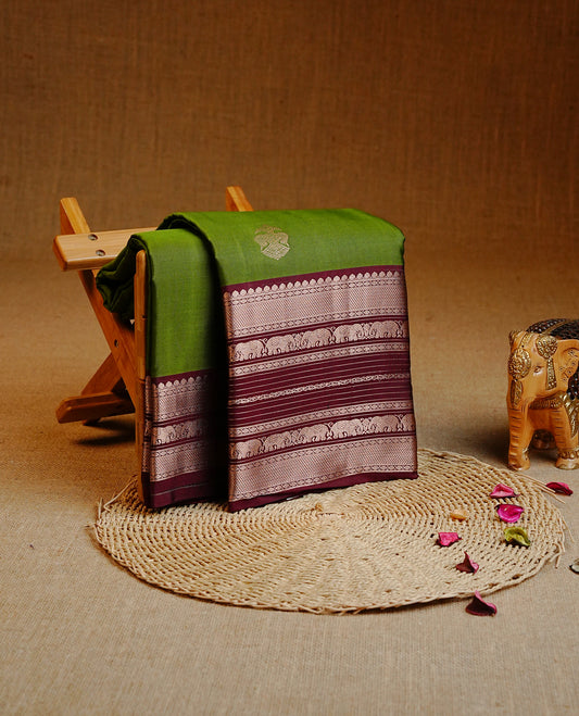 Olive Green Colour Kancheepuram silk saree featuring gold zari motifs on body, highlighting Gold zari Elephant Traditional On contrast Maroon border, paired with Matching blouse piece.