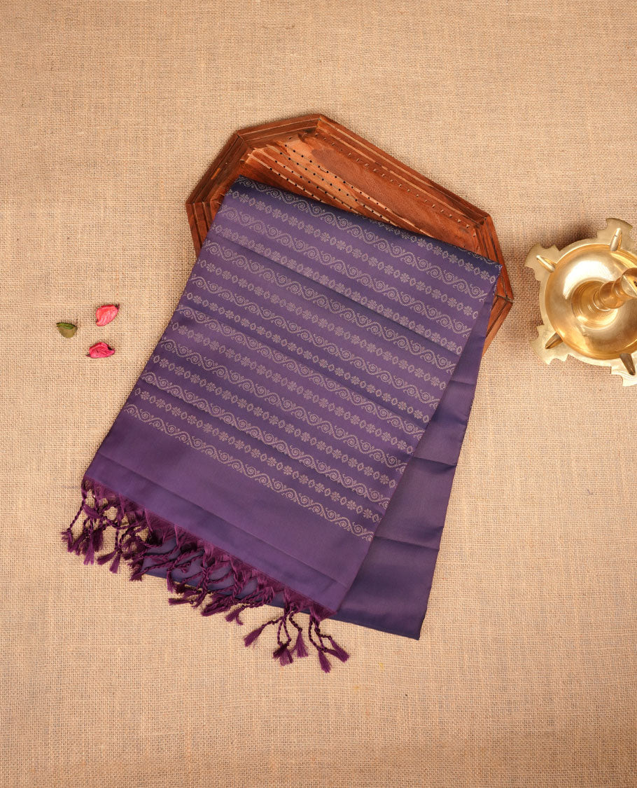 Indigo colour soft silk saree featuring gold zari motifs on body, complemented by self colour with traditional border with tassel at pallu, paired with matching blouse piece.