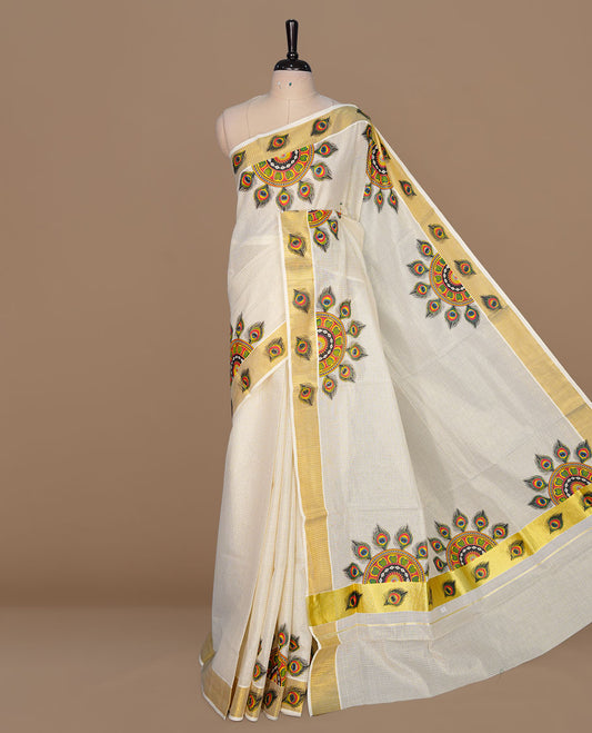 Off white color kerala cotton saree featuring gold zari check on body, complemented by, gold zari with peacock leaf printed border, paired with matching blouse piece.