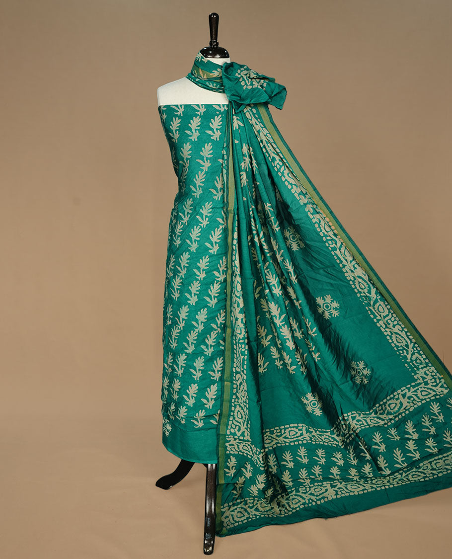 Green colour churidar material featuring cream pattern print on body, paired with matching bottom and dupatta.