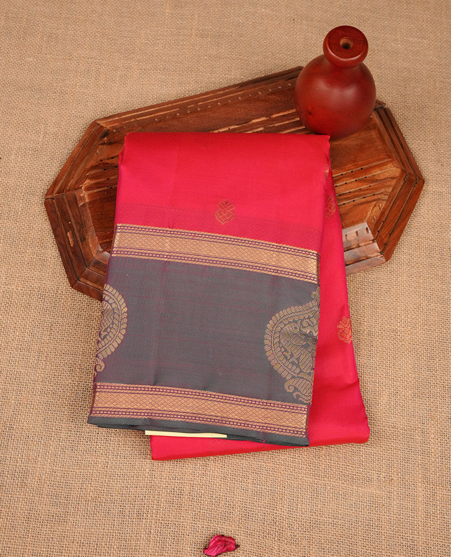 Reddish pink colour vasundhara silk saree featuring zari buttas on body, complemented by contrast green with zari border, paired with matching blouse piece.