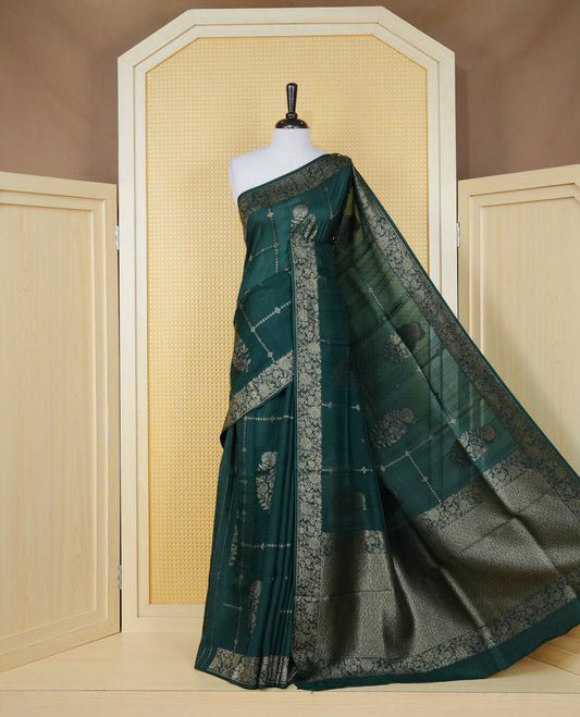 Bottle green colour semi banaras tussar georgette saree featuring gold zari floral pattern on body, finished with gold zari floral motifs on border and paired with matching blouse piece.