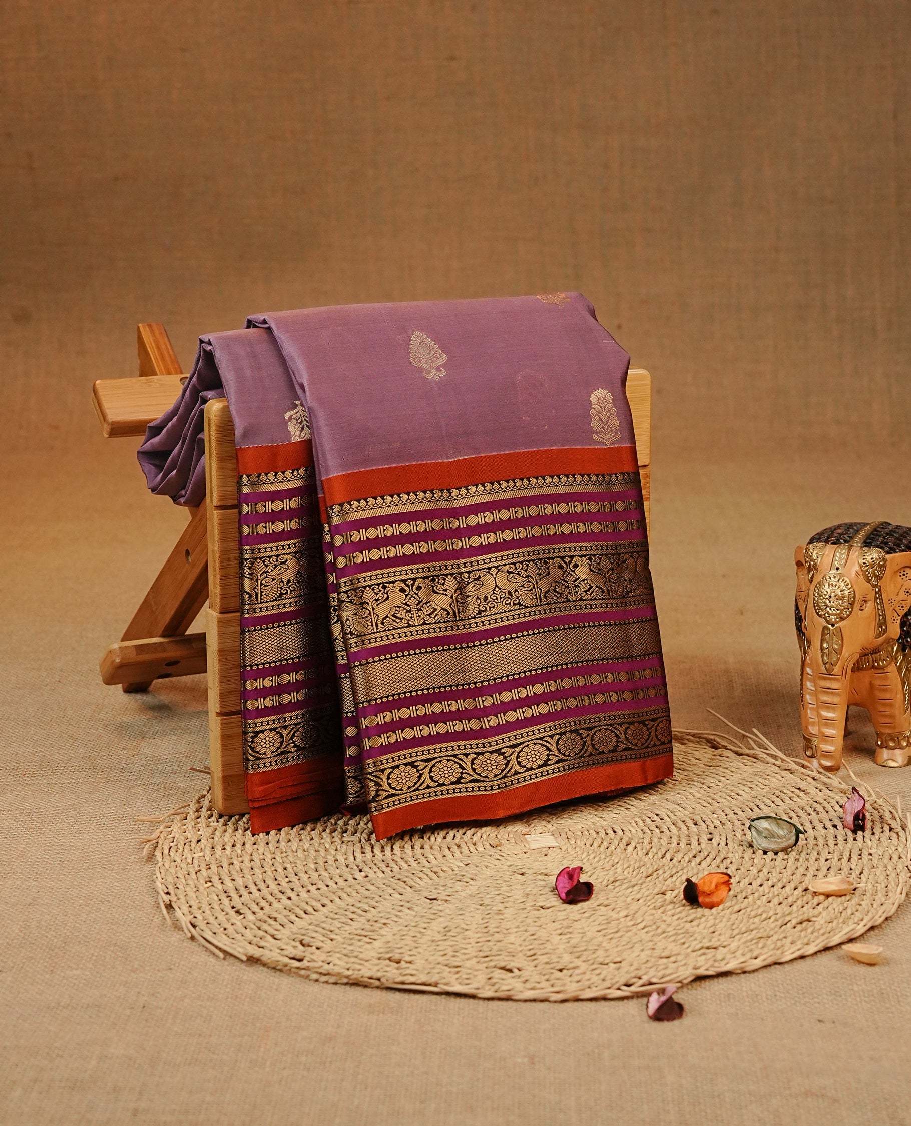 Dusted Lavender colour Kancheepuram silk saree featuring Gold zari Motifs on body, complemented by Multicolour with Traditional border, comes with matching blouse piece.