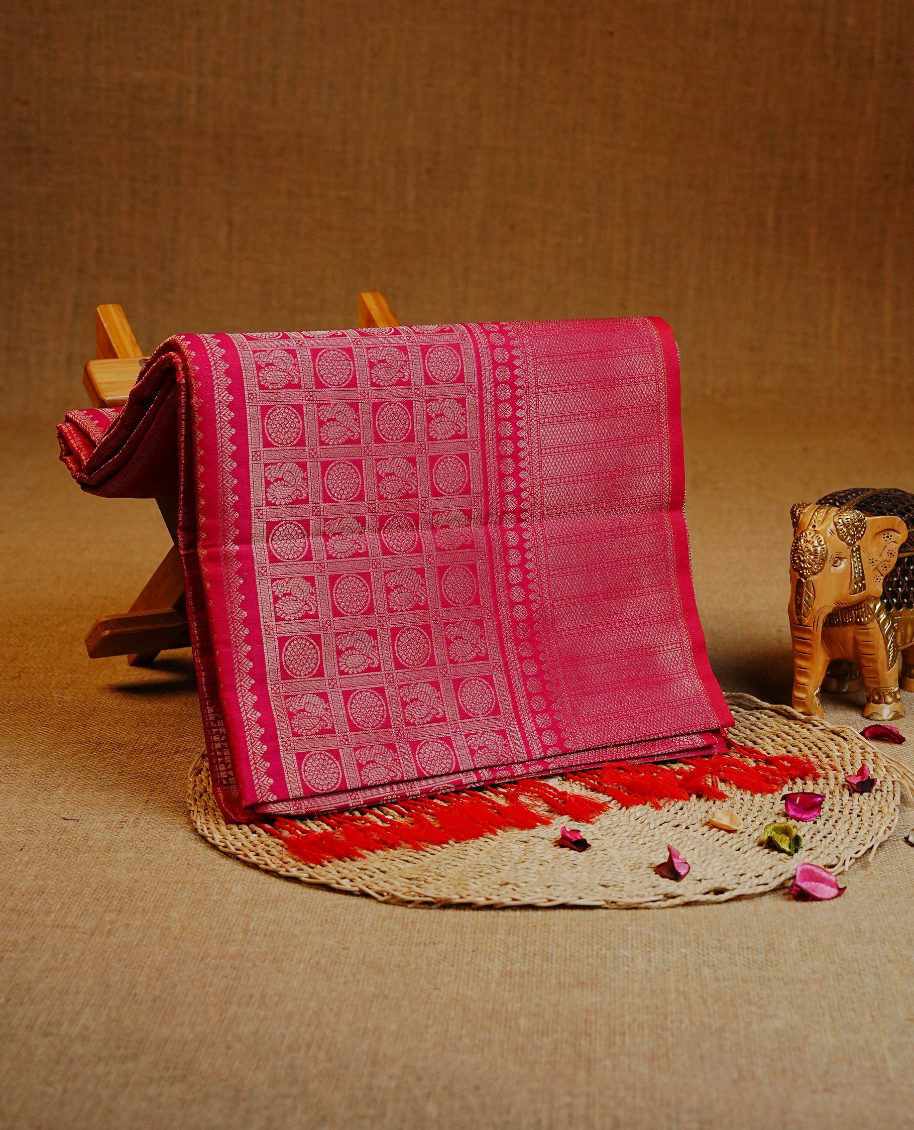 Magenta color Semi Soft Silk Saree Featuring Gold Zari Checks With Delicate Motifs And Stripes Across The Body, Enhanced With A Self Coloured Gold Zari Border, And Paired With A Matching Blouse Piece.