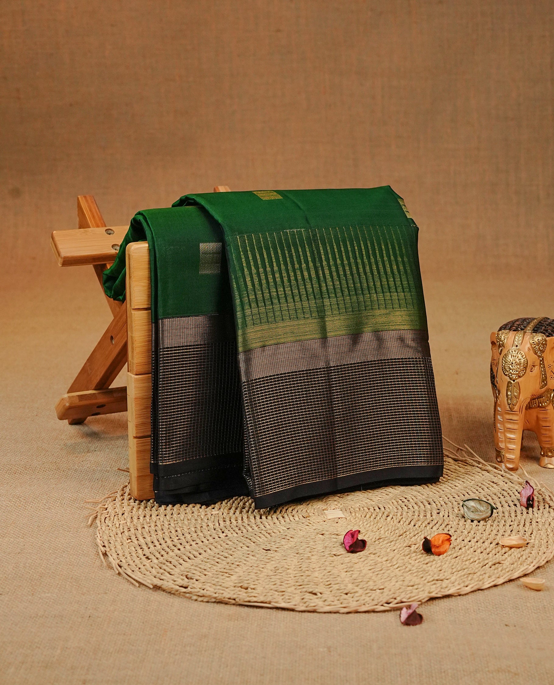 Green colour Kancheepuram silk saree featuring Gold zari box Motifs on body, complemented by Black colour with Traditional border, comes with matching blouse piece.