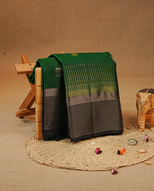 Green colour Kancheepuram silk saree featuring Gold zari box Motifs on body, complemented by Black colour with Traditional border, comes with matching blouse piece.