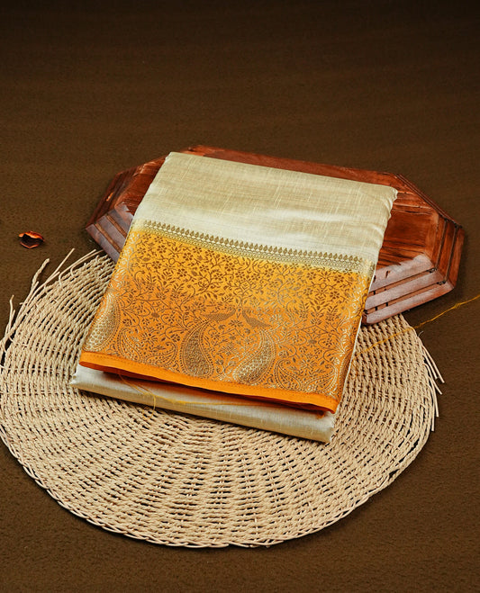 Light gold tussar saree featuring Elegant plain body, complemented by contrast Orange yellow  colour with Gold zari Floral kodi with Peacock Pattern border, comes with matching blouse piece.