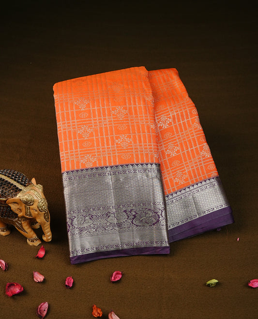 orange colour semi wedding silk saree featuring light gold zari checks with florals on body, contrast purple colour with traditional border on body, rich pallu comes with matching blouse piece
