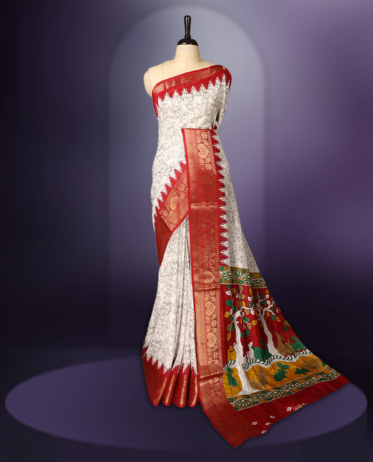 White colour  saree adorned with delicate black floral prints across the body, enhanced by a rich red and gold zari border, featuring a vibrant artistic pallu with traditional motifs, paired with a matching blouse.