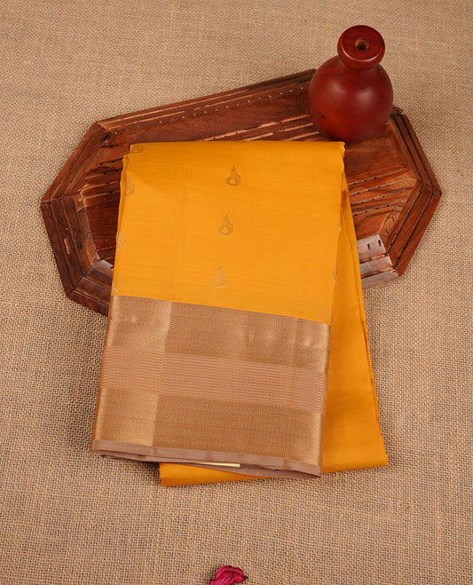 Mango yellow coloue vasundhara silk saree featuring zari buttas on body, complemented by contrast chikku with traditional border, paired with matching blouse piece