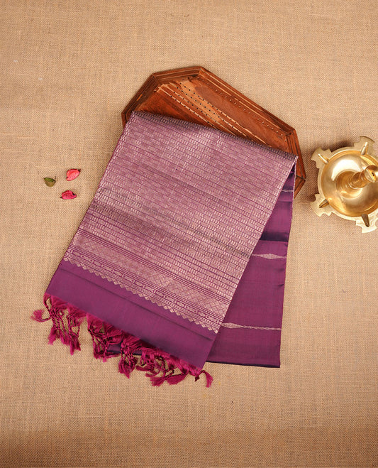 Purple colour soft silk saree featuring gold zari motifs on body, complemented by self colour with traditional border with tassel at pallu, paired with matching blouse piece.