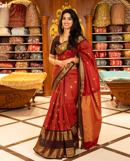 Maroon with Brown Chettinad cotton saree featuring Gold zari strips with peacock motifs on body, complemented by contrast colour border with zari design & grand pallu, comes with matching blouse piece.