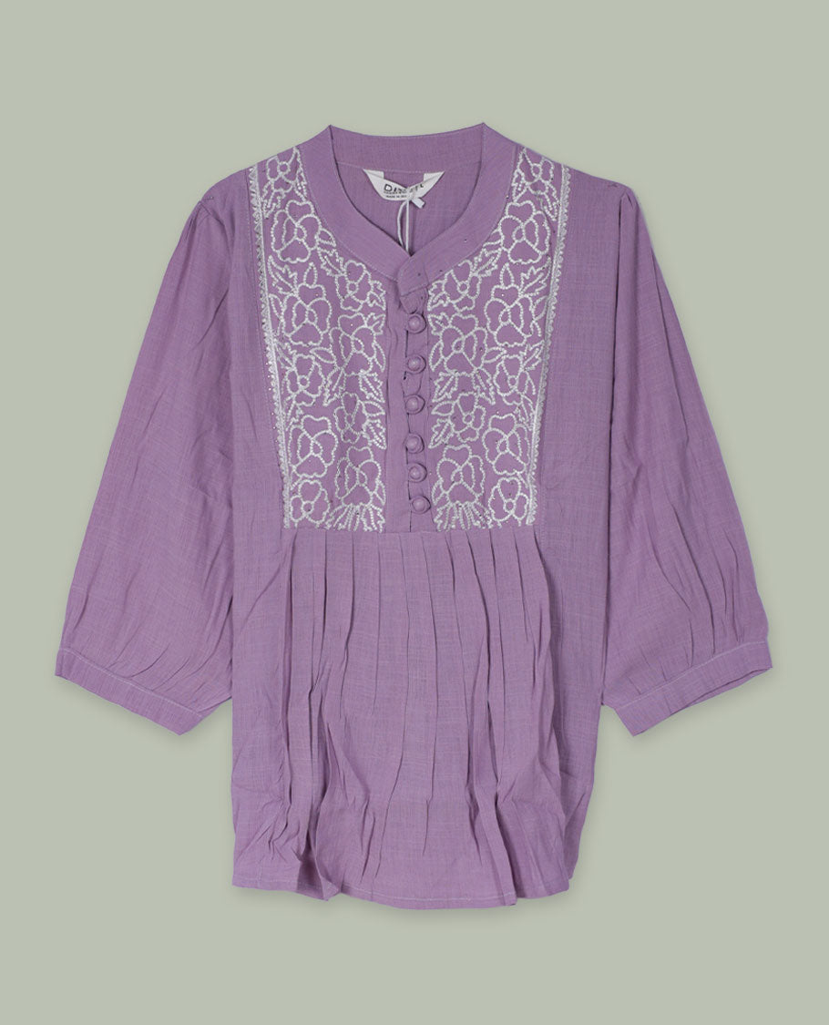Lilac three-quarter sleeve tunic top with rounded band neckline, white floral embroidered yoke, fabric-covered button placket, and soft pleating below the yoke.