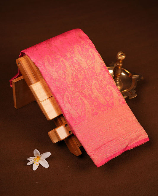 Peachish Pink colour semi soft silk brocade saree featuring delicate floral woven motifs across the body, finished with an intricately detailed traditional pallu and a matching blouse.