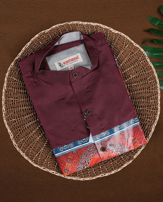 Maroon men’s shirt tailored in a smooth finish, designed with a mandarin collar, full sleeves, and highlighted with an intricate multicolour Theyyam inspired print panel on the front, perfect for festive and cultural wear.