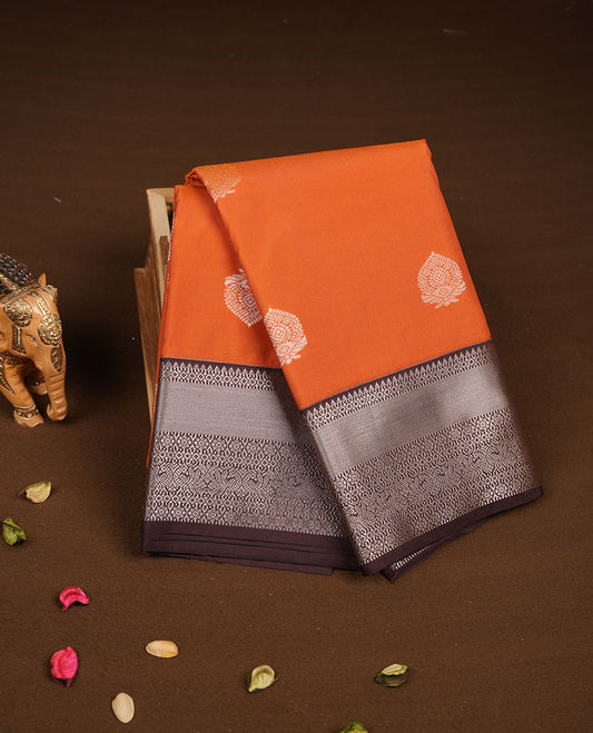 Rust orange colour semi silk saree featuring gold zari floral  motifs on body highlighting contrast dark chocolate rose gold zari peacock border , paired with matching blouse